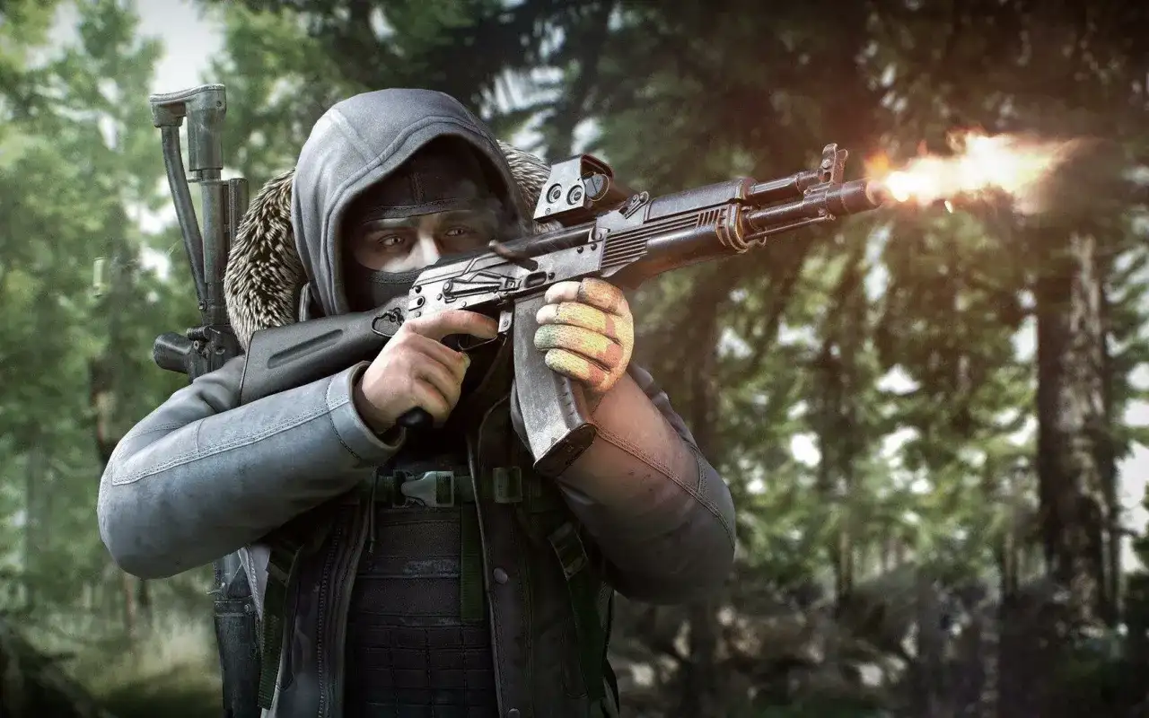 Gracz w masce i kapturze strzela z karabinu w lesie. To scena z gry Escape from Tarkov, gdzie cena przetrwania jest wysoka.