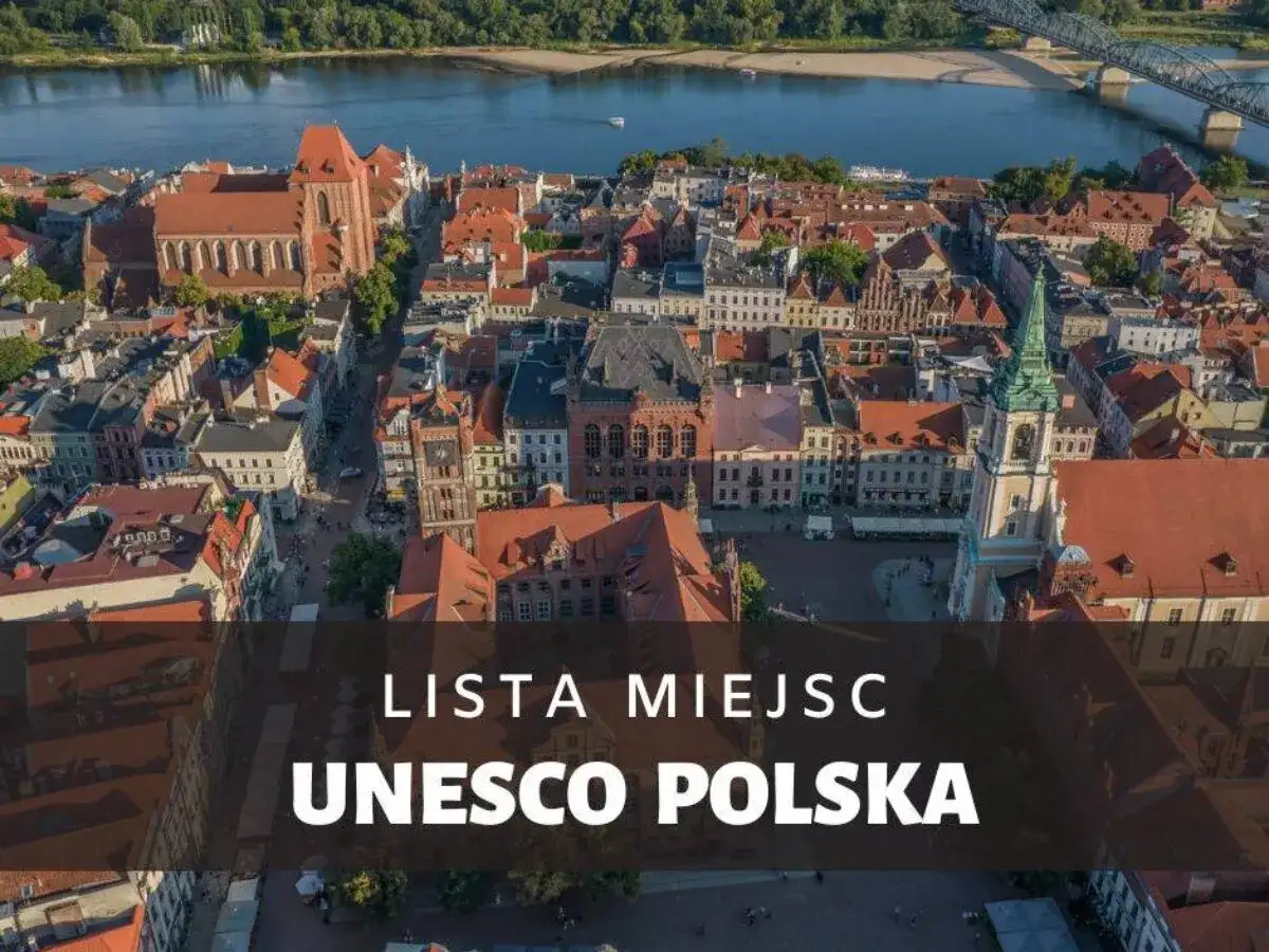Widok z lotu ptaka na zabytkowe miasto z czerwonymi dachami i rzeką. Napis "Lista Miejsc UNESCO Polska" podkreśla jego znaczenie.