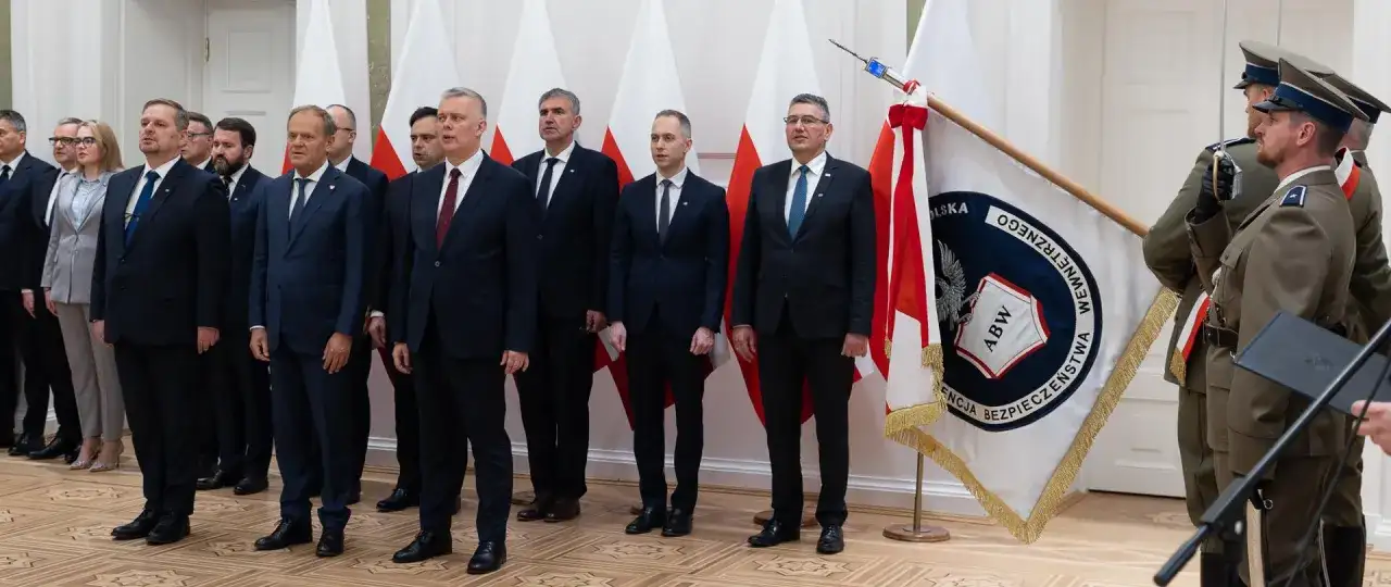 Uroczystość z udziałem premiera Tuska we Włocławku. W tle flagi Polski i ABW.