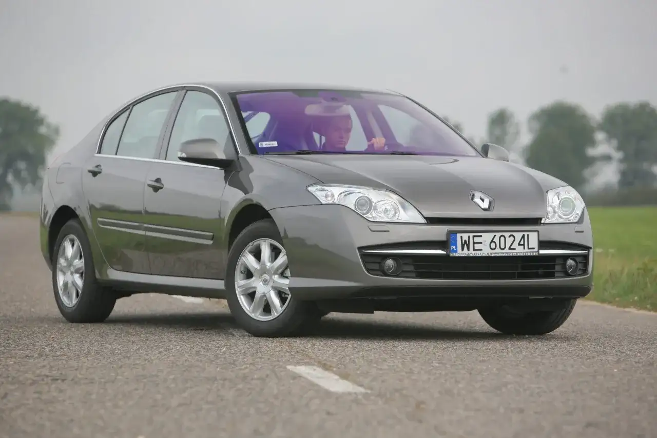 Szary sedan Renault Laguna 3 na drodze. Rozmiar opon jest standardowy dla tego modelu, zapewniając komfortową jazdę.