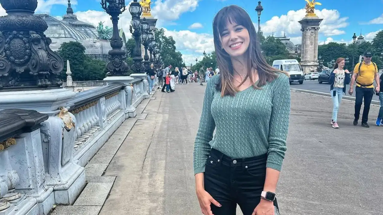 Marta Abramczyk, w wieku około 20 lat, uśmiecha się na moście w Paryżu.