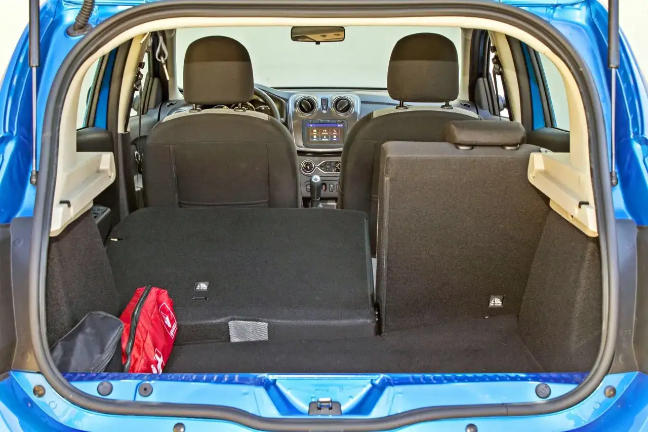 Bagażnik Dacia Sandero, gotowy na podróż. Widoczna apteczka i torba.