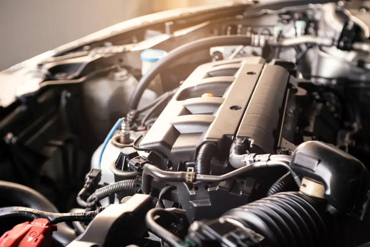 Zbliżenie na silnik samochodowy BMW E91, widoczne przewody i elementy mechaniczne.