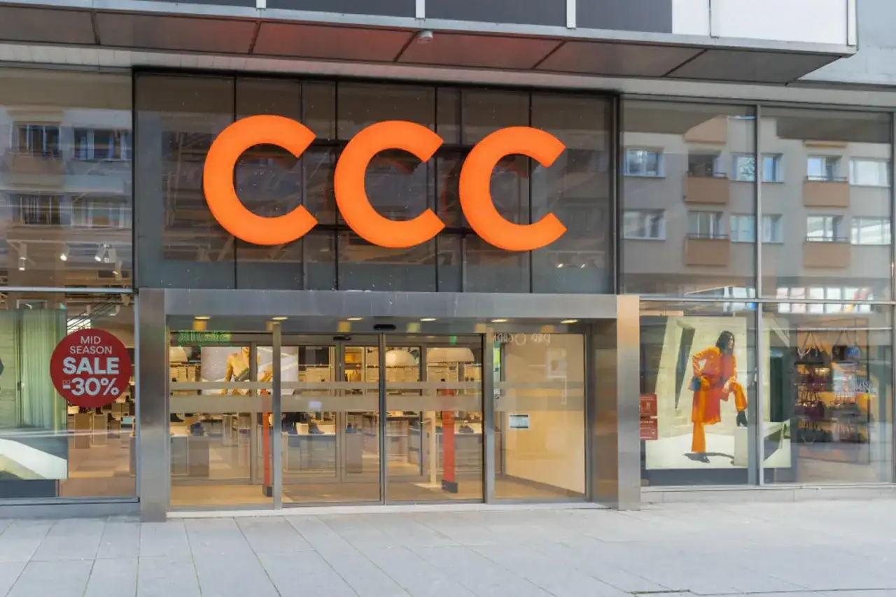 Elegancka fasada sklepu CCC z pomarańczowym logo i witryną z promocją -50%.
