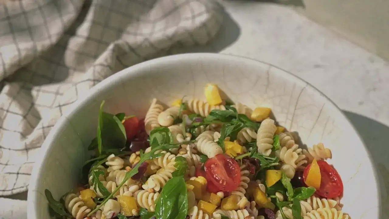 Leckerer Weight Watchers mediterraner Pastasalat mit Fusilli, Kirschtomaten, Rucola und gelber Paprika in einer Schüssel.