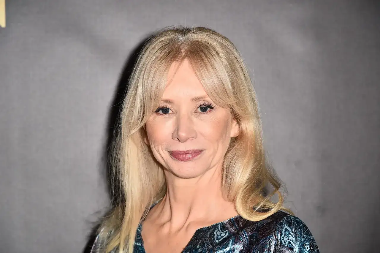 Portret Ewy Gawryluk, aktorki, której wiek dodaje jej uroku. Jej blond włosy i delikatny makijaż podkreślają urodę.