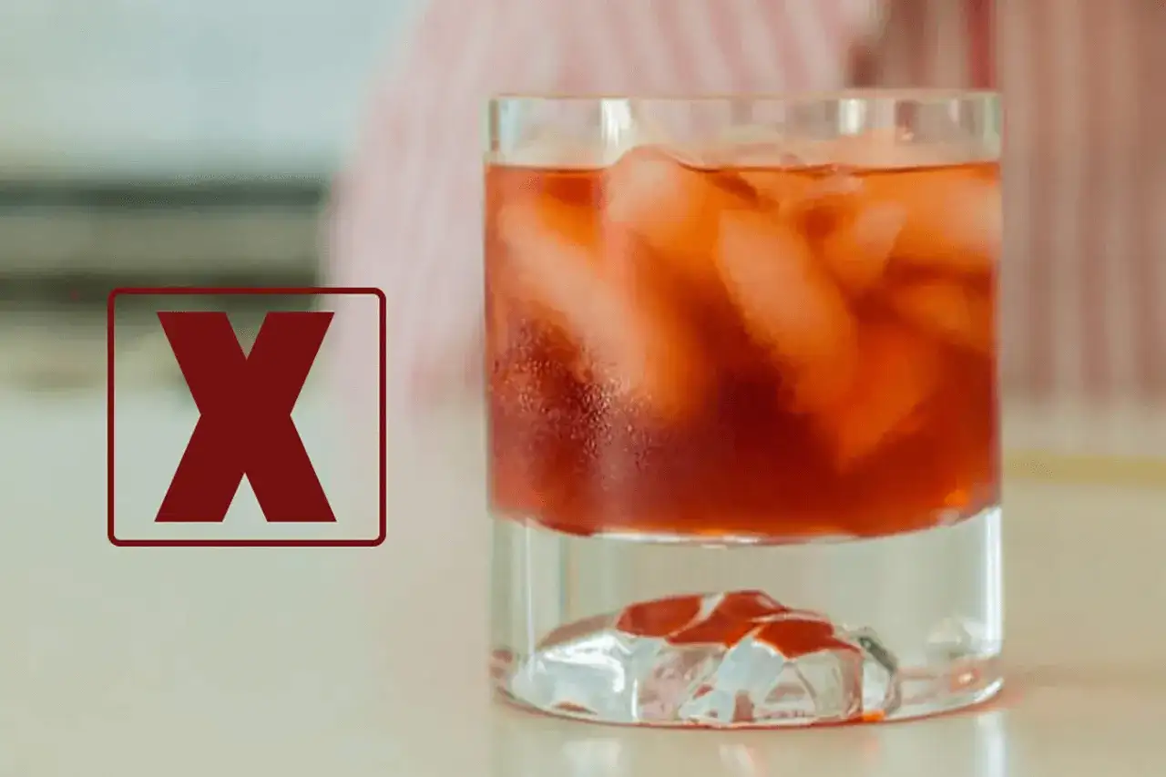 Czerwony znak "X" obok drinka z lodem. Dlaczego negroni musi być mieszane, a nie wstrząsane w shakerze, by zachować idealny smak.