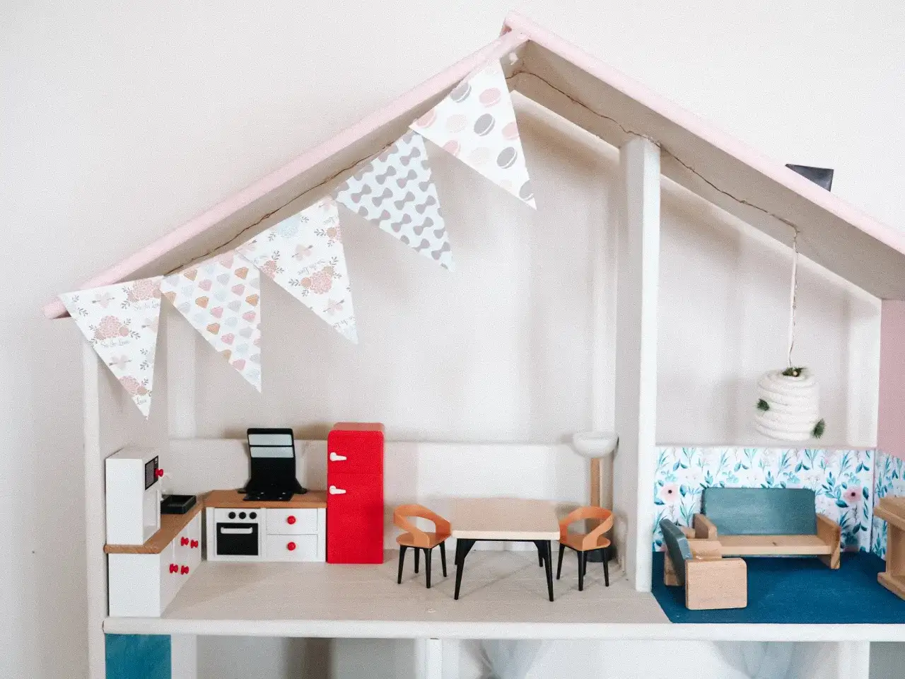 Urocze meble dla lalek diy: kuchnia z lodówką, stół z krzesłami i salon z kanapą.