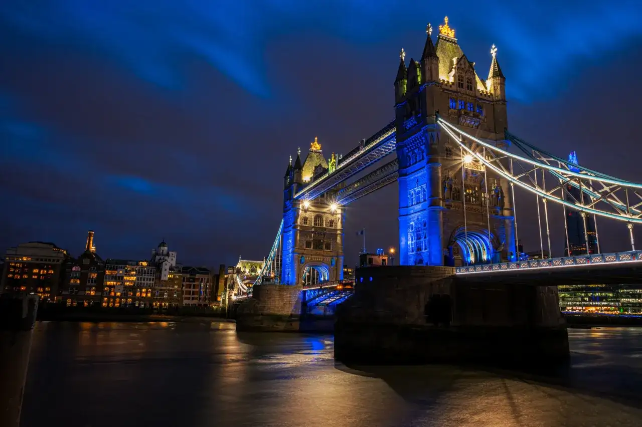 Tower Bridge w Londynie, jedna z głównych wielka brytania atrakcje, nocą, oświetlona na niebiesko.