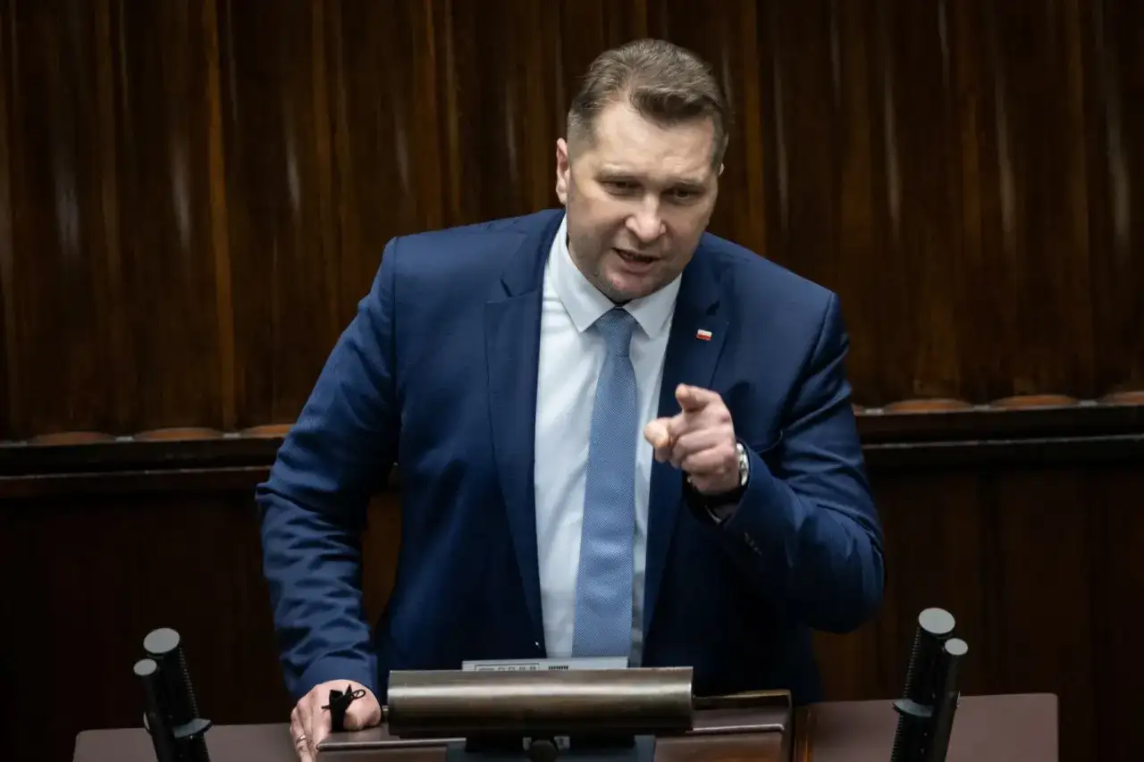 Mężczyzna w garniturze przemawia, wskazując palcem. Dyskusja dotyczy ustawy Lex Czarnek.