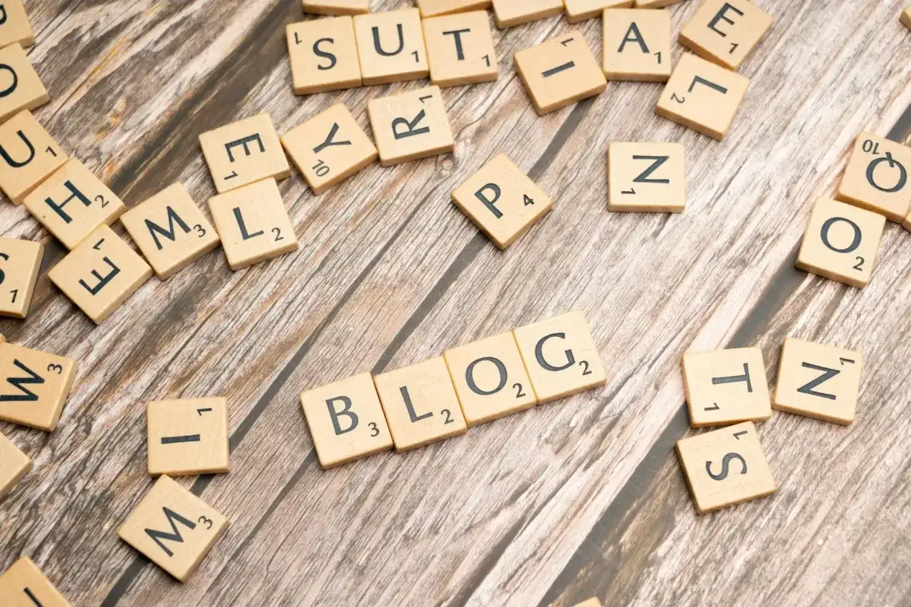 Litery układają się w słowo BLOG, sugerując, jak założyć bloga i zarabiać.
