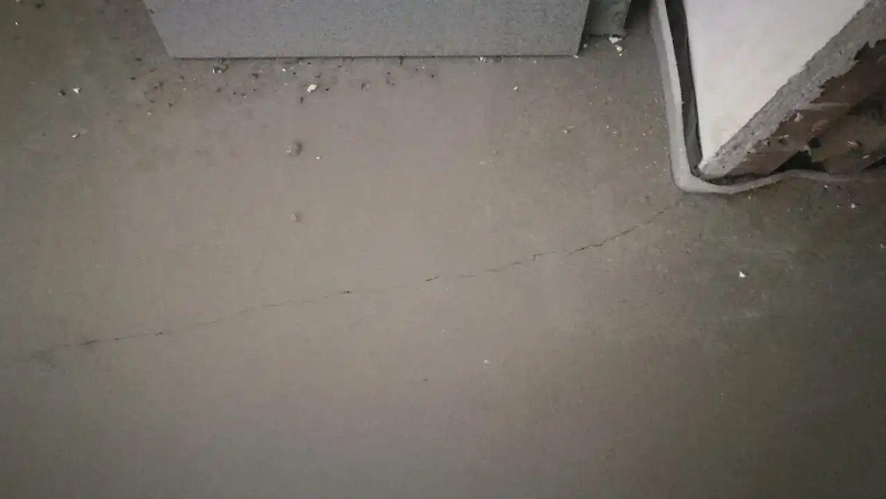 Szara, świeża posadzka z widocznym pęknięciem, przygotowywana do wygrzewania.