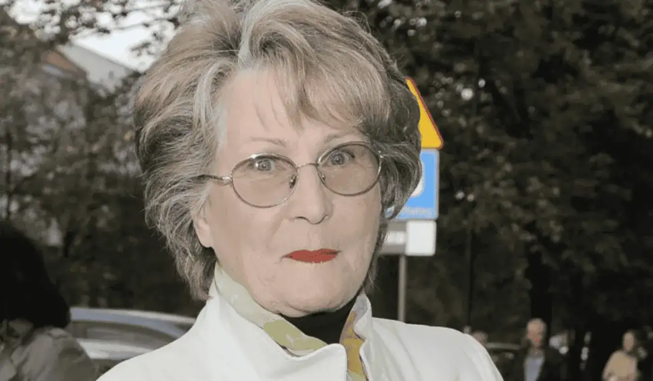 Irena Santor w okularach, z czerwoną szminką na ustach, w białej kurtce. Myśli o swoich dzieciach.