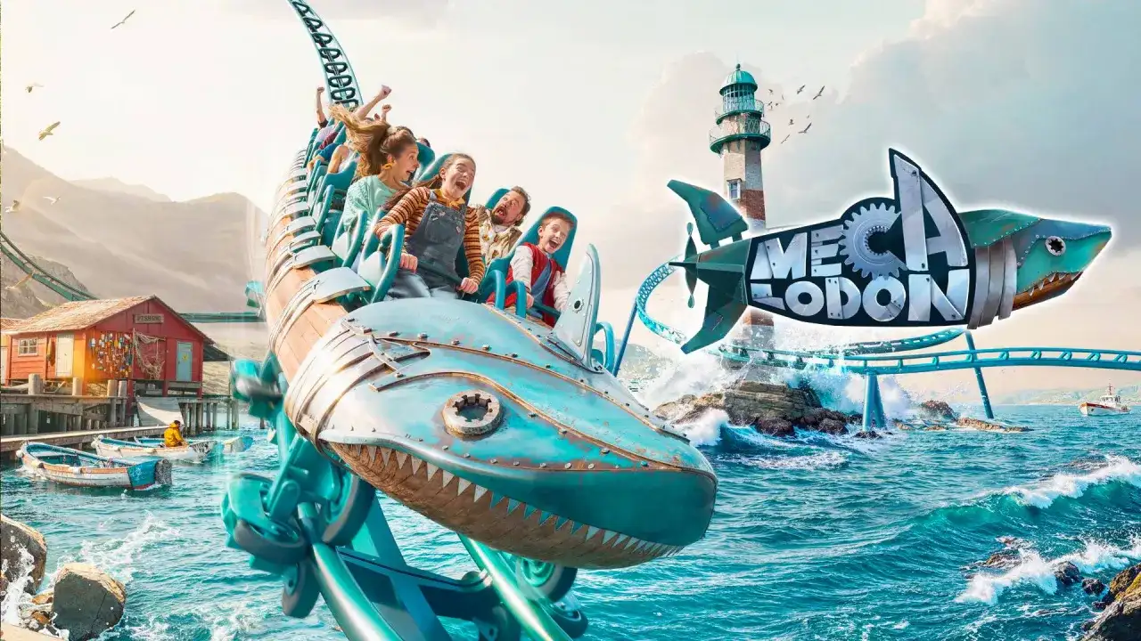 Un train de montagnes russes en forme de requin mécanique sur l'eau, avec un phare et un village de pêcheurs.