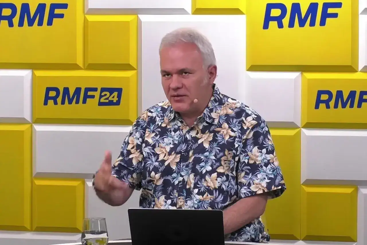 Mazurek z RMF FM w hawajskiej koszuli gestykuluje podczas rozmowy.