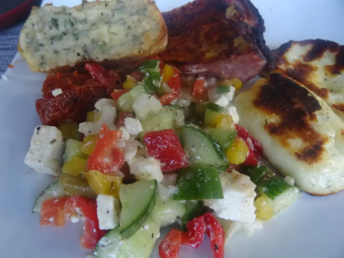 Frischer Paprika Gurken-Salat mit Feta, dazu gegrilltes Fleisch und Brot. Ein Genuss!
