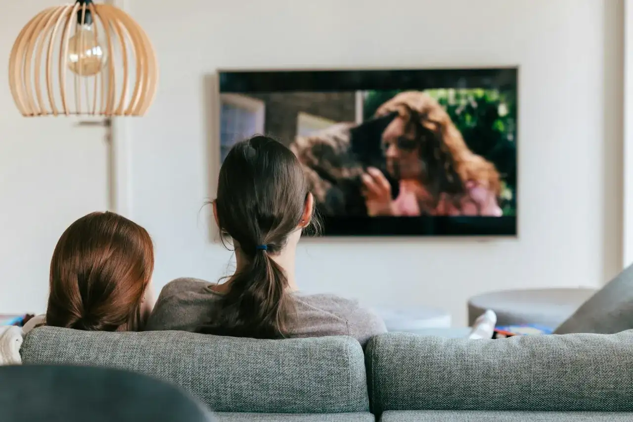Dwie osoby oglądają film na telewizorze. Szukają sposobu, jak znaleźć film, którego tytułu nie pamiętam, opisując scenę z ekranu.