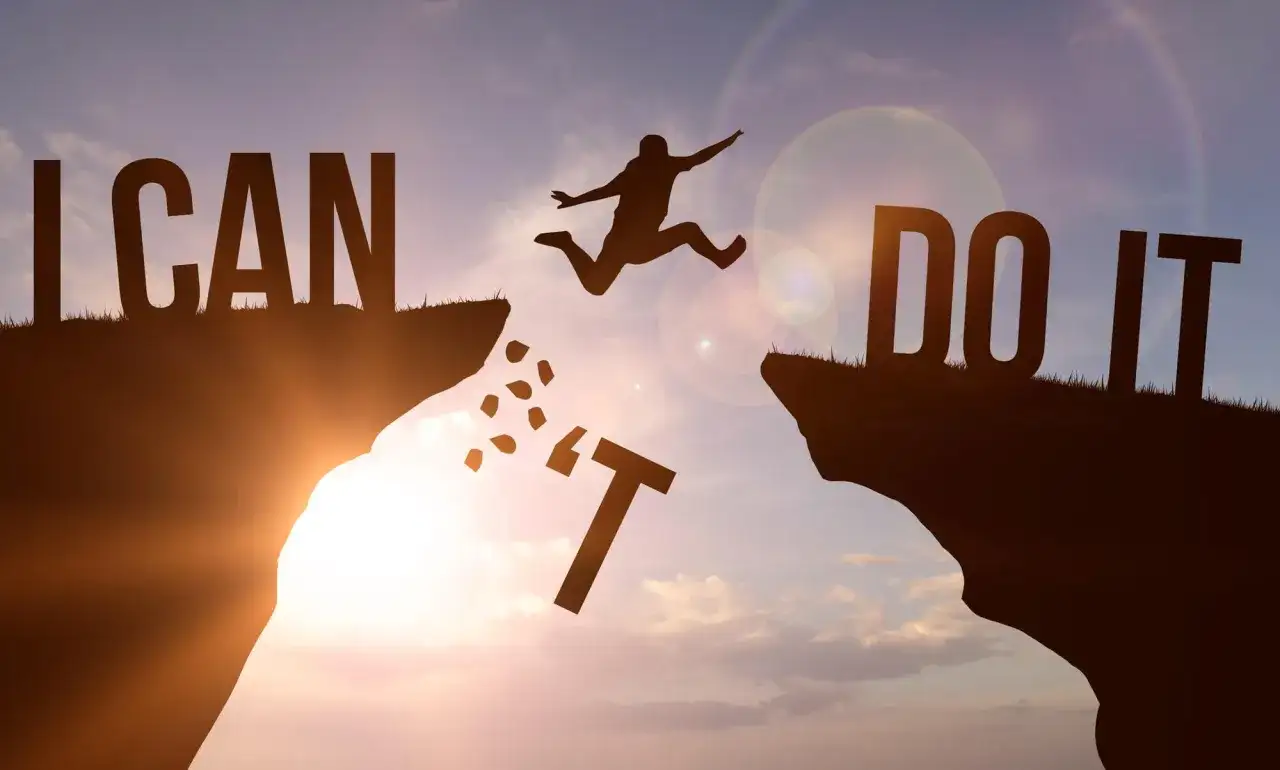 Sylwetka skacze przez przepaść, pokonując przeszkody. Napis "I CAN DO IT" symbolizuje siłę woli i motywację, jak w mądrych cytatach po angielsku.