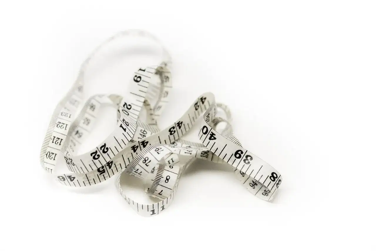 Miarka krawiecka, symbol dążenia do idealnych wymiarów kobiecej sylwetki.