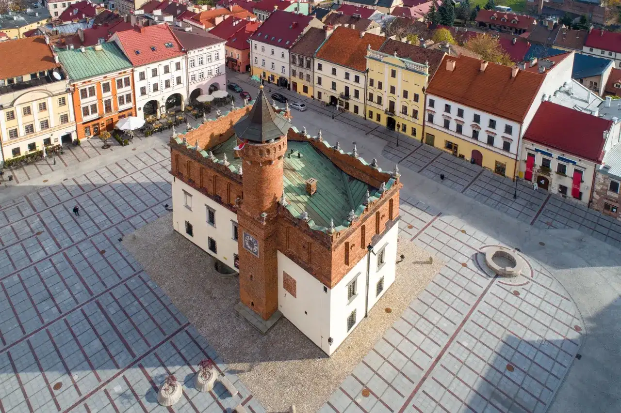 Rynek w Tarnowie, polskim biegunie ciepła, z ratuszem i kolorowymi kamienicami.