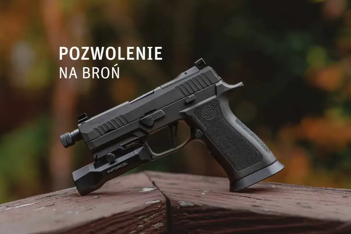 Czarny pistolet z latarką na drewnianym blacie, z napisem "POZWOLENIE NA BROŃ".