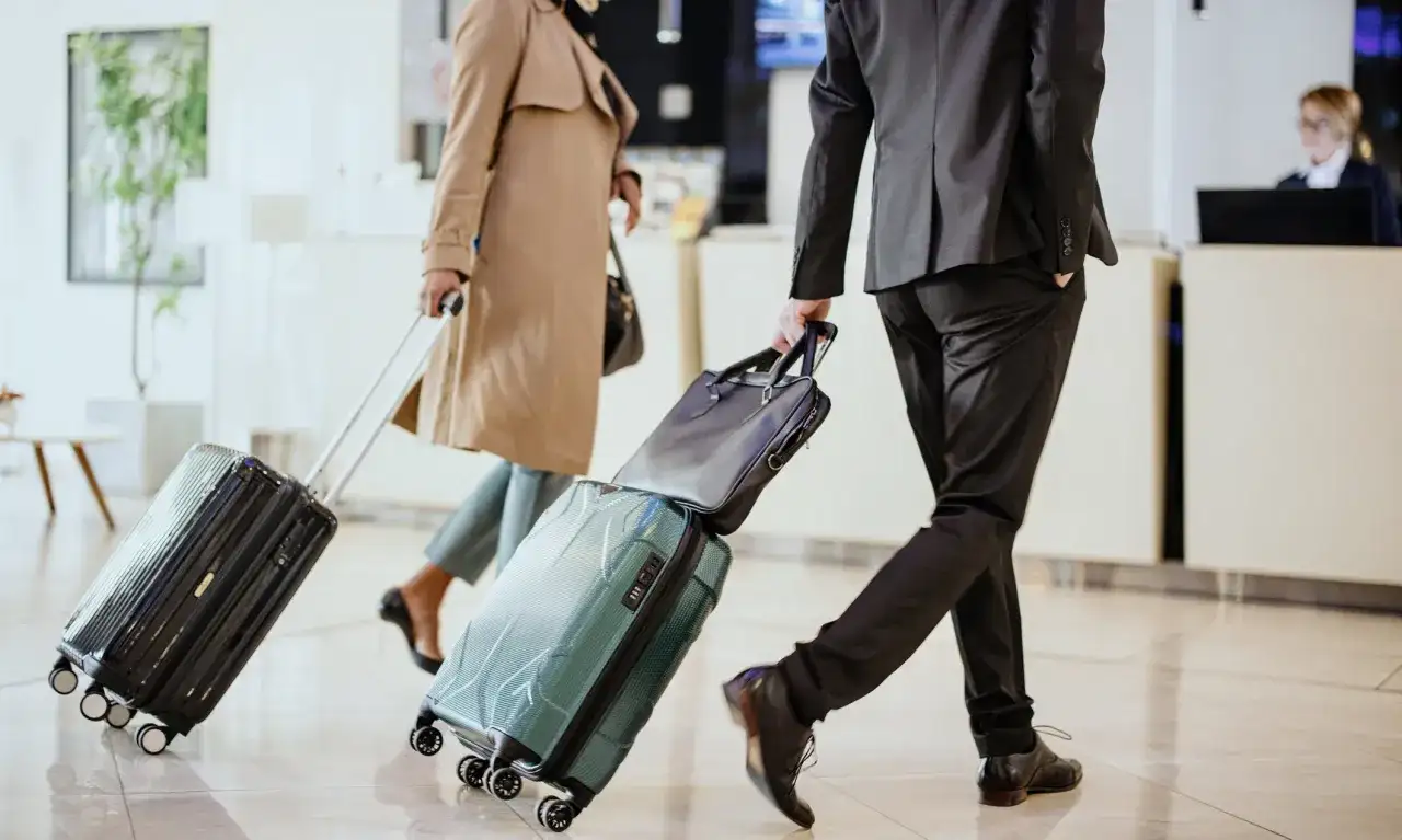 Biznesmeni z walizkami spieszą się, by zdążyć na samolot. Ciekawe, ile czasu na wypłatę delegacji mają po powrocie.