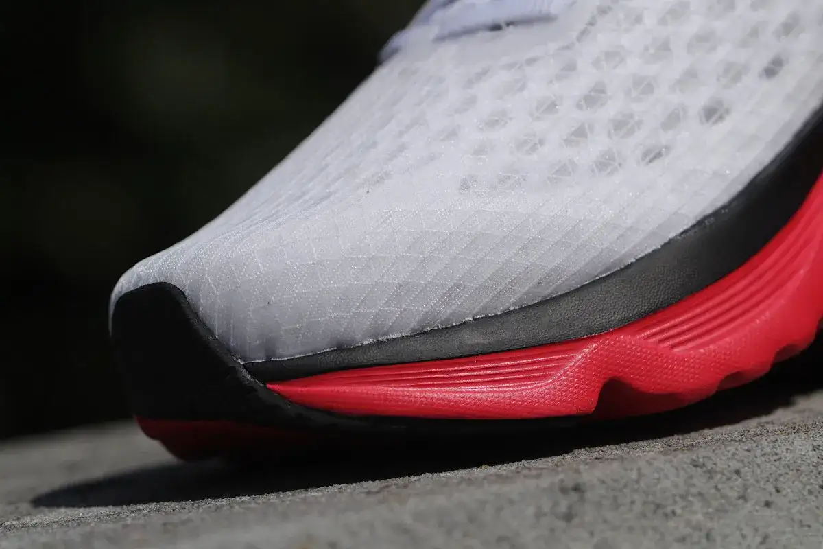 Białe buty treningowo startowe z czerwoną podeszwą, gotowe na każdy bieg.