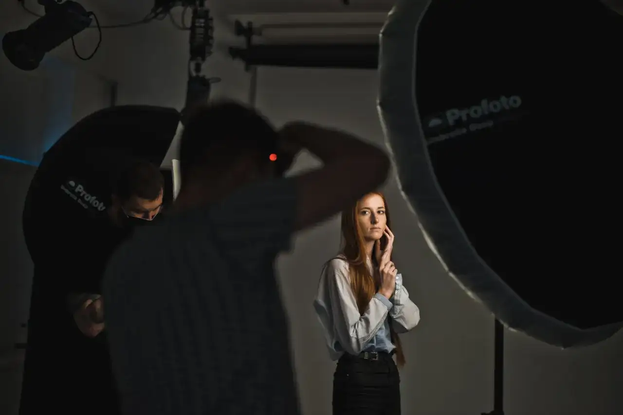 Sesja zdjęciowa w studiu. Fotograf z aparatem, modelka i oświetlenie. Inspiracja dla blogi o fotografii.