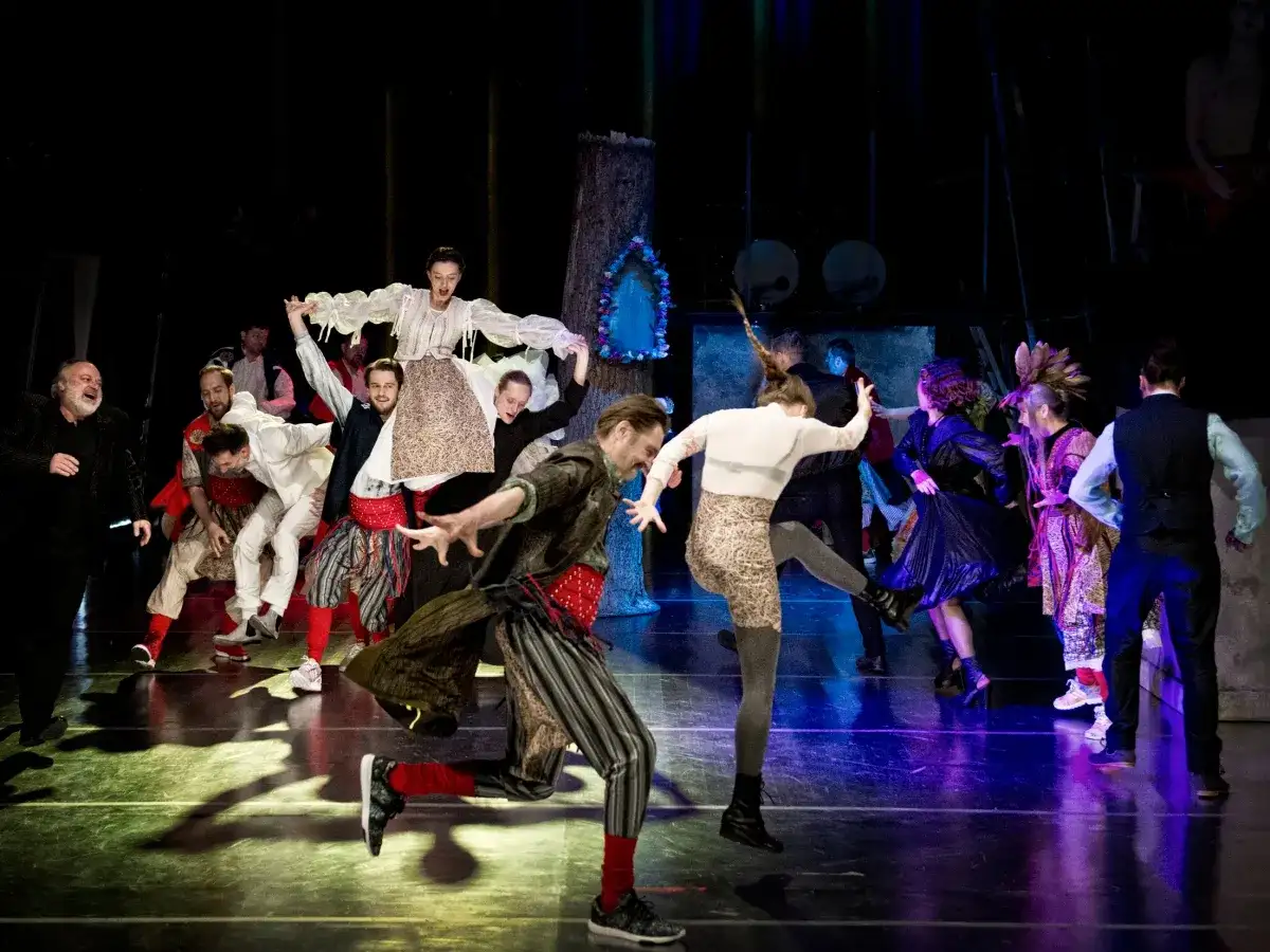 Scena teatralna z ludźmi w strojach ludowych. Wesele, co symbolizuje chocholi taniec, to chaos i utrata kontroli.