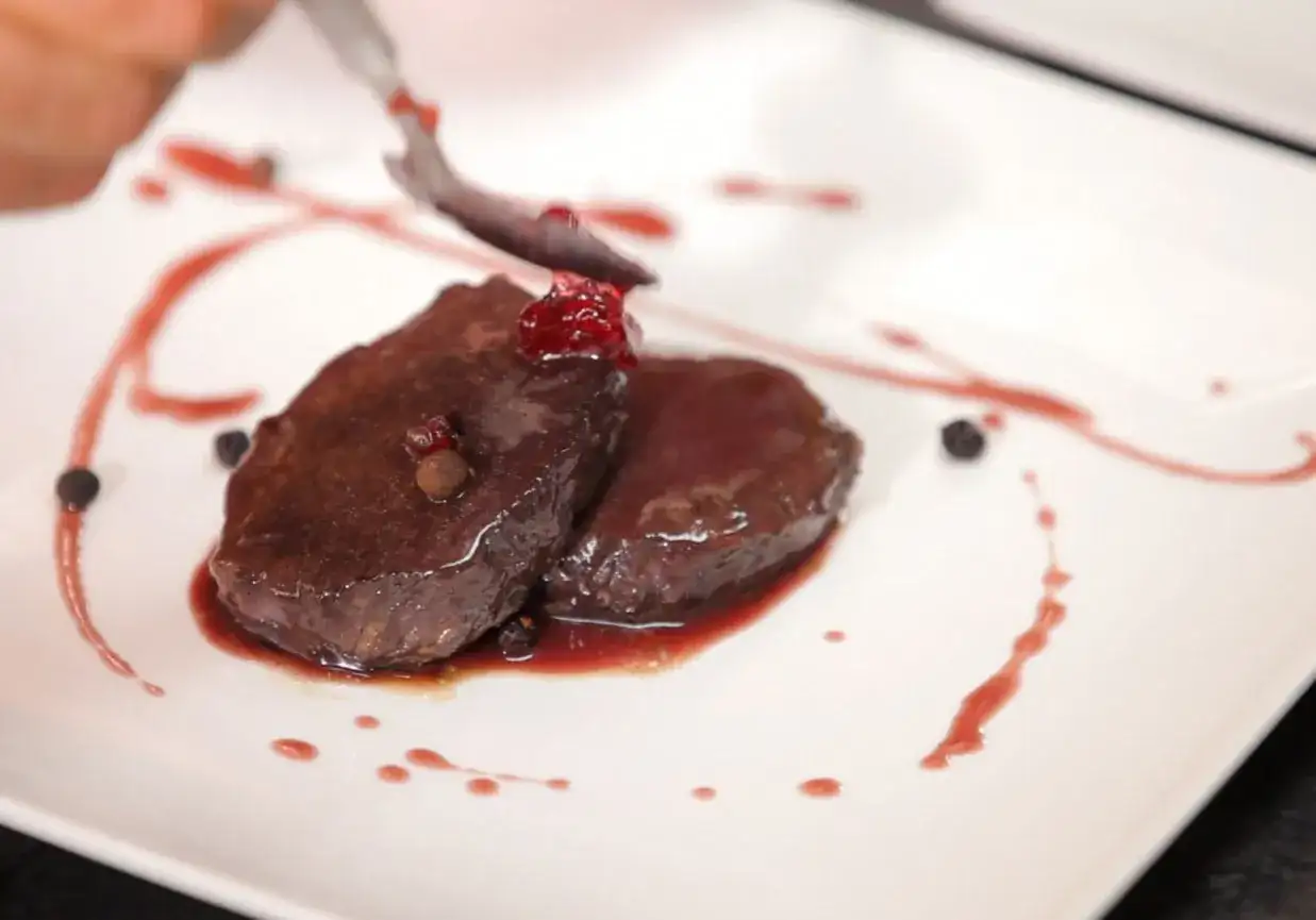 Elegancko podany schab z jelenia, polany sosem z owoców leśnych. Idealny przykład, jak przygotować schab z jelenia na specjalną okazję.