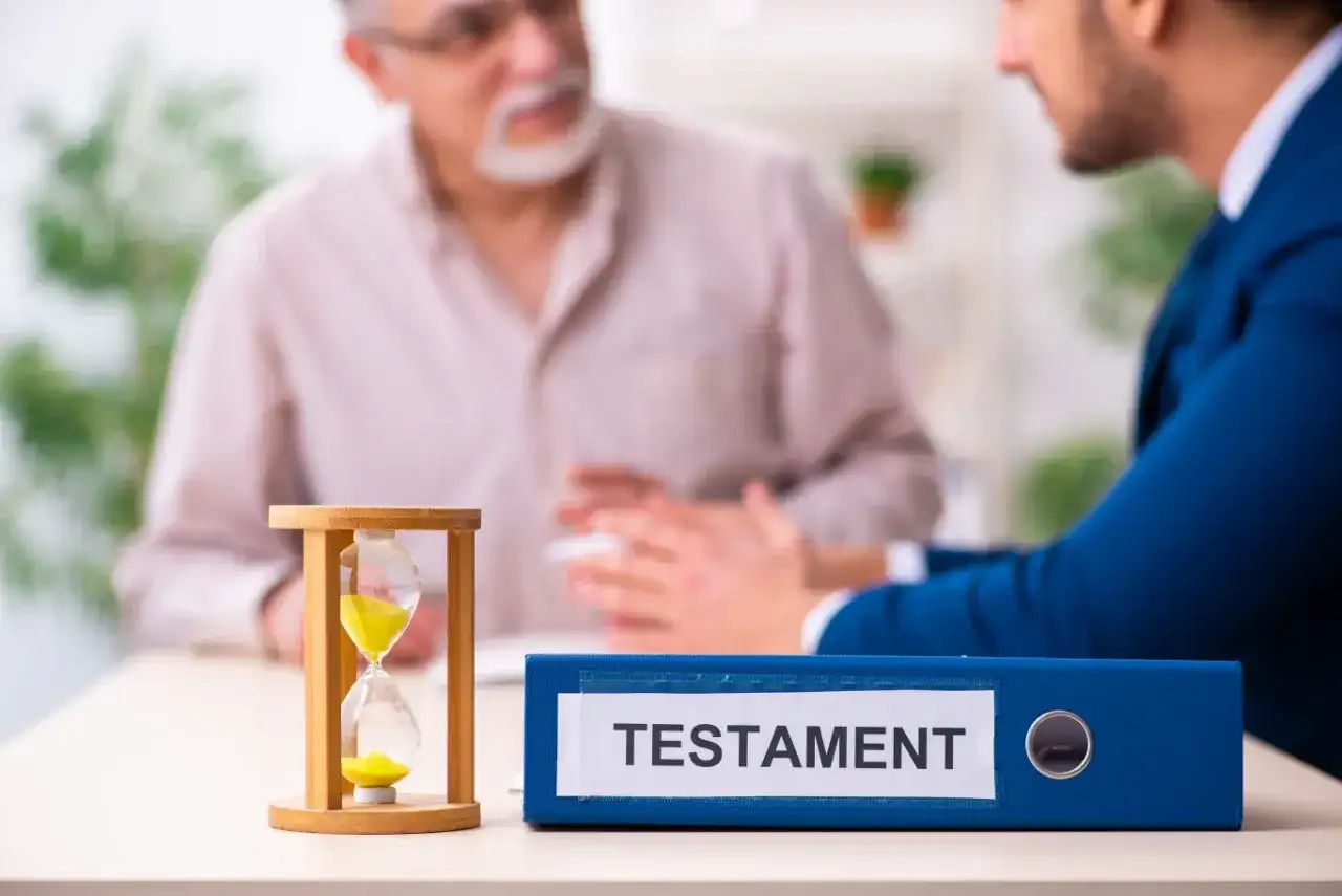 Klepsydra i segregator z napisem "TESTAMENT" na stole, podczas rozmowy dwóch mężczyzn.