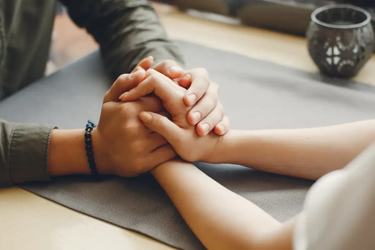 Dłonie splatają się, pokazując, jak przywiązuje się mężczyzna. Bliskość i wsparcie w geście.