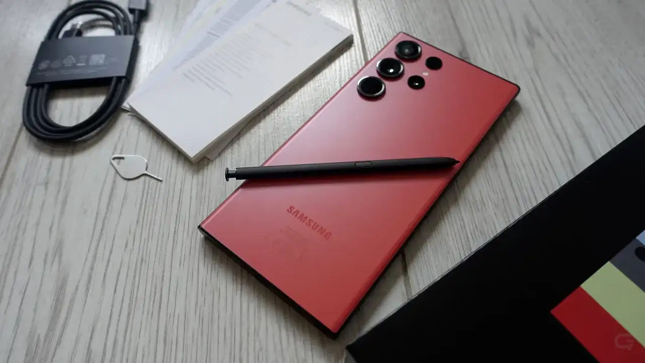 Czerwony Samsung S23 Ultra z rysikiem i akcesoriami. Aparat tego modelu pozwala na robienie niesamowitych zdjęć.