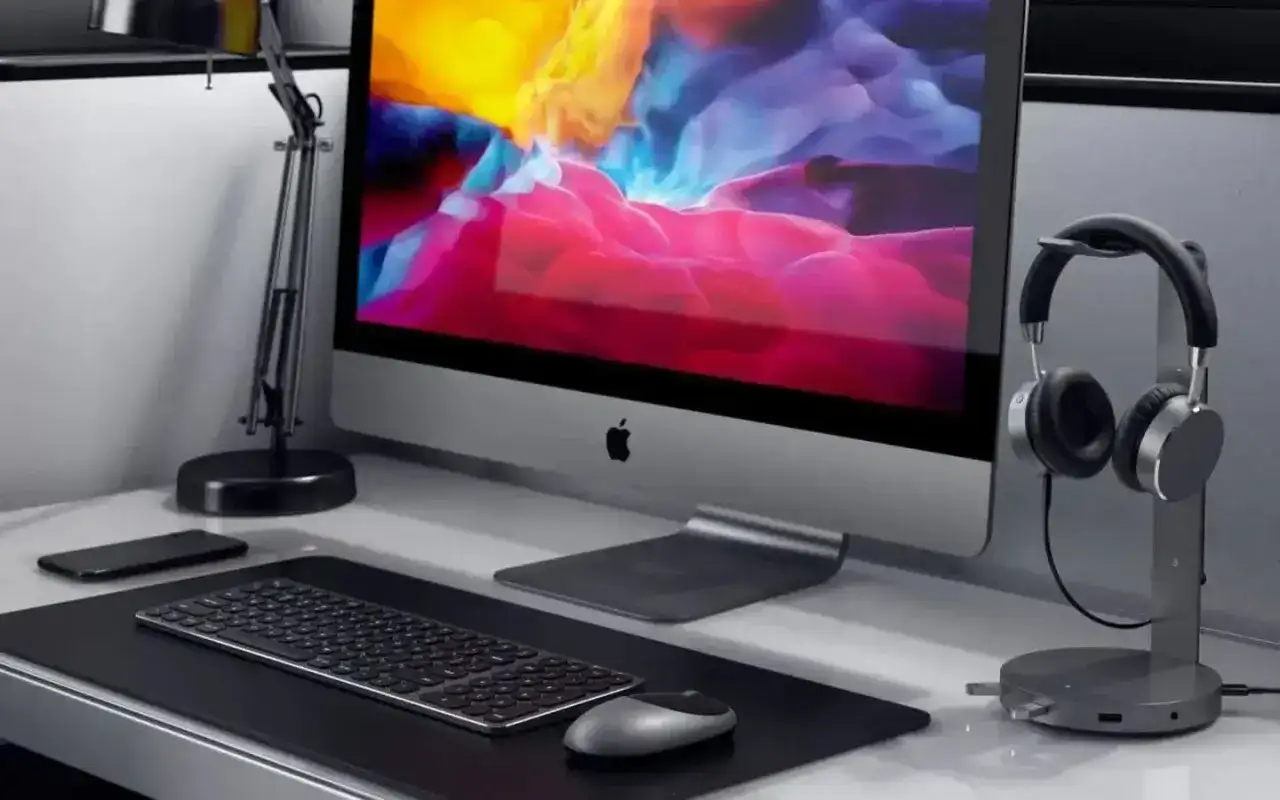Elegancka podstawka pod słuchawki obok komputera iMac.