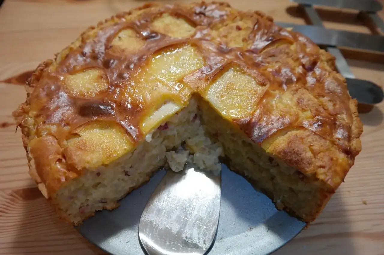 Apetyczna babka ziemniaczana z kawałkiem wyjętym łopatką. Idealna na obiad, a jak długo piec babkę ziemniaczaną? Zależy od piekarnika!