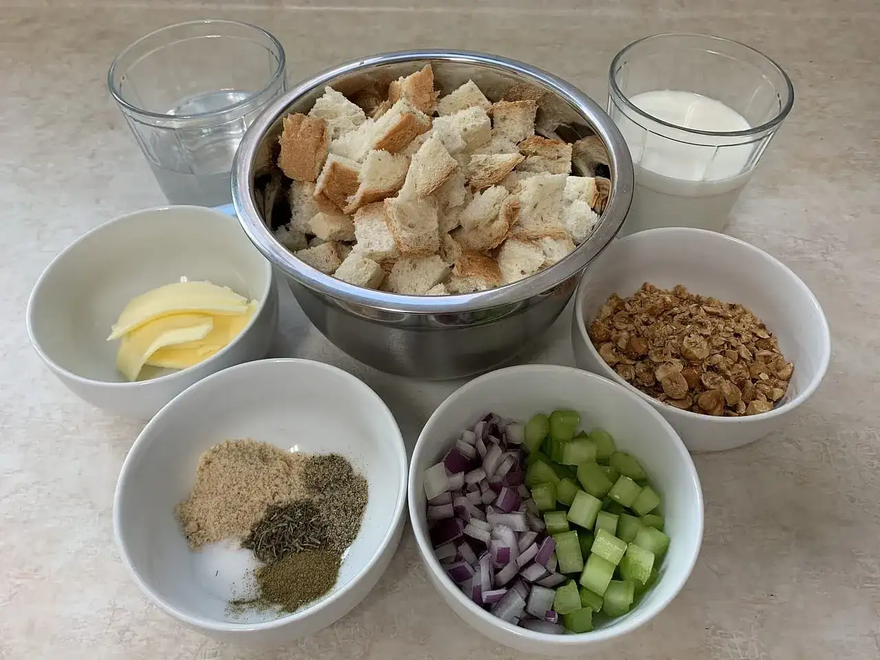 Składniki do farszu: pokrojony chleb, masło, cebula, seler, orzechy, przyprawy, mleko i woda.