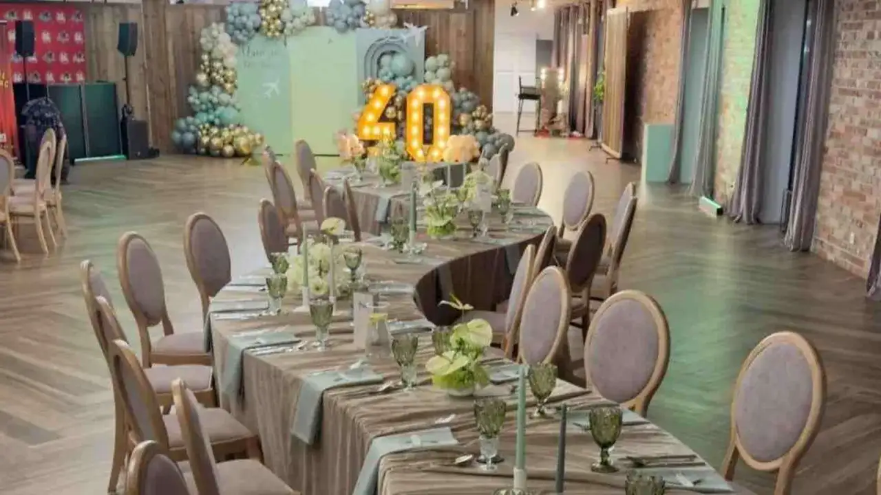 Elegancka sala bankietowa z nakrytymi stołami na 40 osób, balony i podświetlana liczba "40" sugerują, że to miejsce na udaną imprezę.