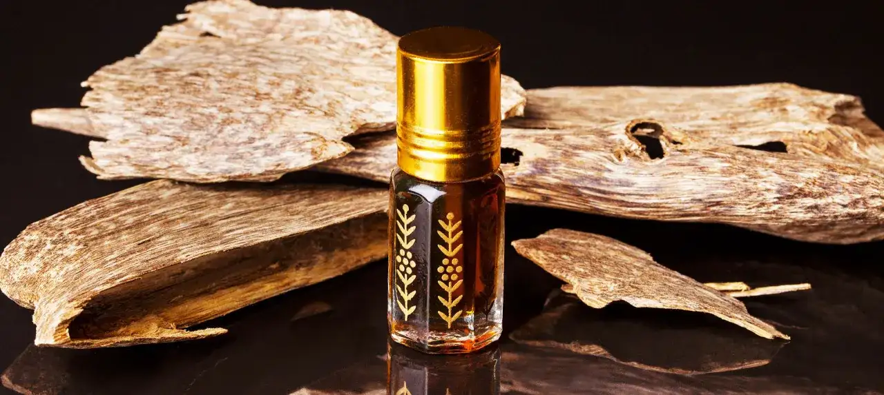 Kleines Fläschchen mit goldenem Verschluss und Oud-Holzstücken.