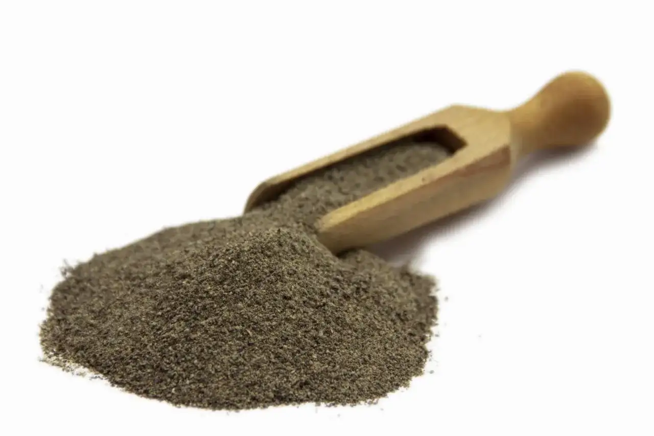 Stos mielonego pieprzu czarnego 1kg na drewnianej łyżce, gotowy do przyprawienia potraw.