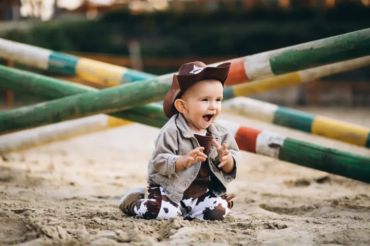 Mała kowbojka w brązowym kapeluszu i spodniach w cętki, gotowa na przygody. Idealny strój kowbojki dla dziewczynki.
