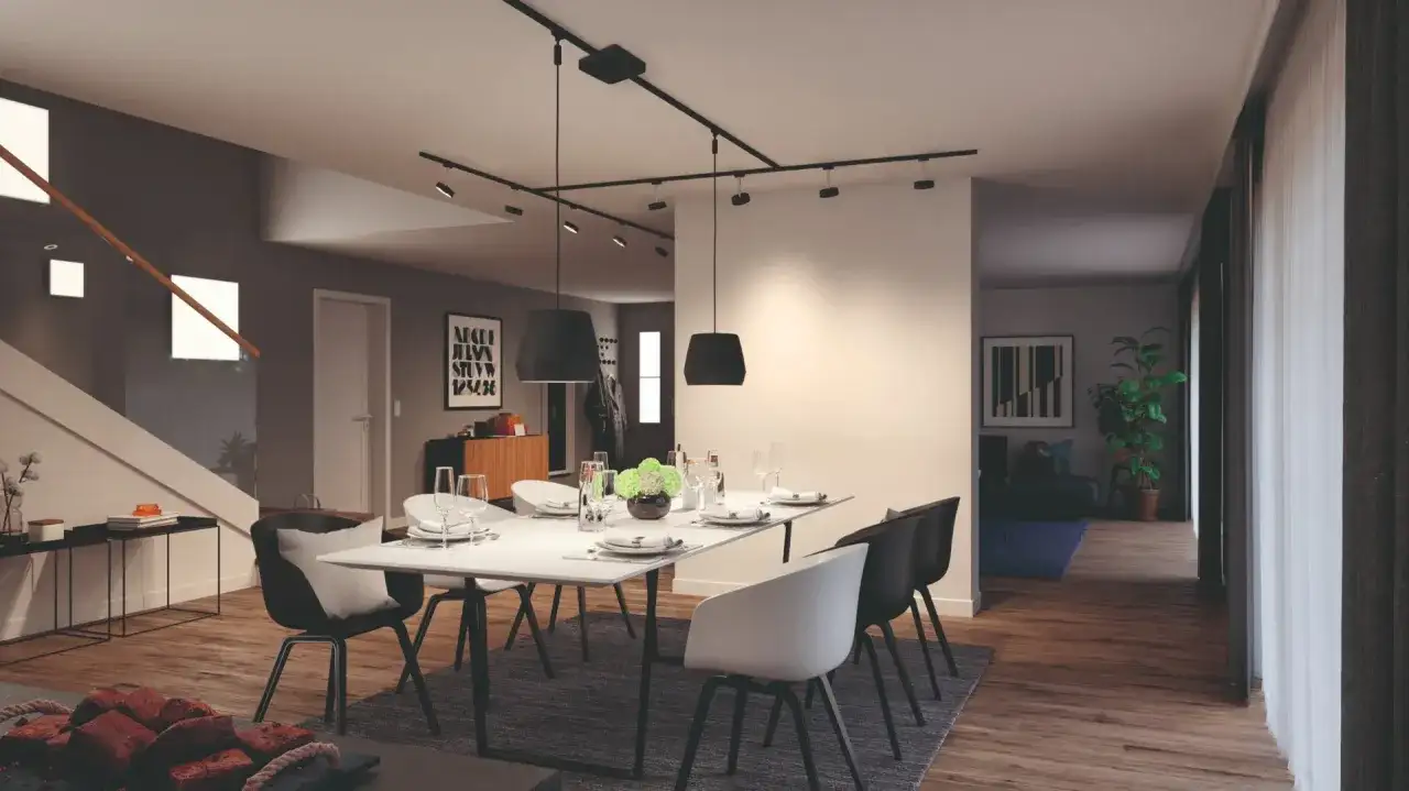 Nowoczesny salon z jadalnią, gdzie centralnym punktem jest stół z krzesłami, a nad nim elegancki system oświetlenia szynowego.
