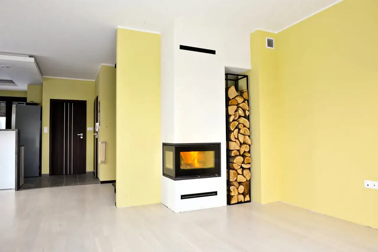 Nowoczesna zabudowa kominka z miejscem na drewno. Instrukcja montażu? Nie, to gotowe rozwiązanie do salonu.