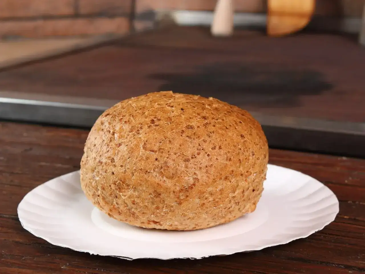 Bułka grahamka na białym talerzyku. Zastanawiasz się, ile kalorii ma bułka grahamka?