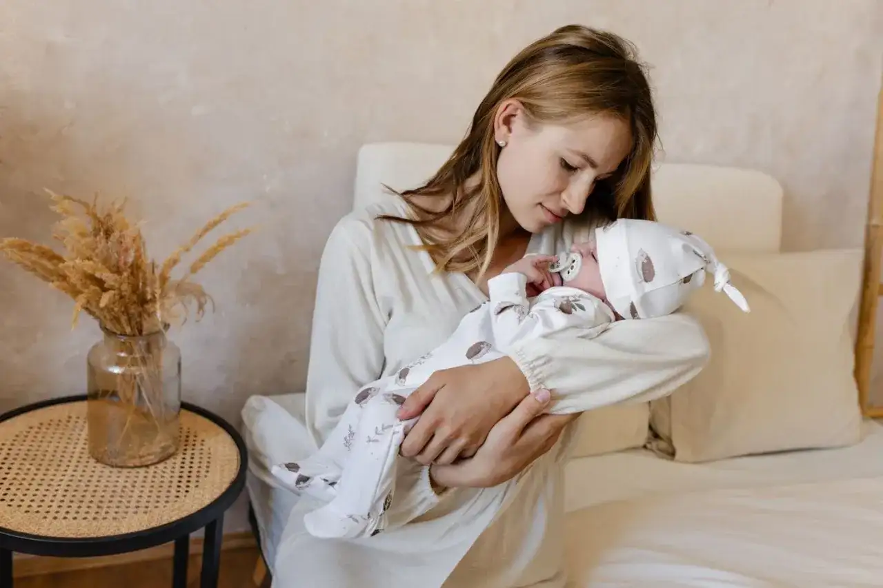 Mama tuli noworodka, myśląc o nowoczesnych imionach dla dziewczyn.