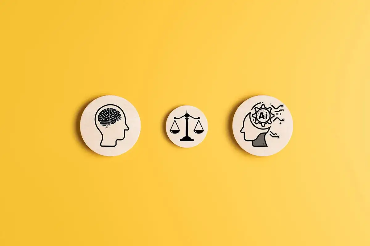 Trzy drewniane krążki na żółtym tle: ludzki mózg, waga sprawiedliwości i głowa z symbolem AI w środku, ilustrują, jak sztuczna inteligencja może rozwiązać dylematy etyczne.