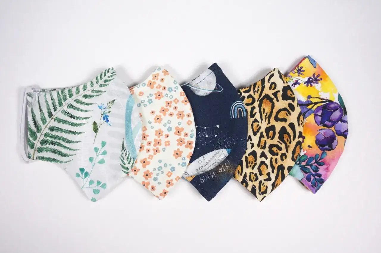 Sześć maseczek ochronnych z różnych tkanin: liście paproci, kwiaty, kosmos, panterka, kwiaty. Z czego uszyć maseczkę? Z kolorowych materiałów!