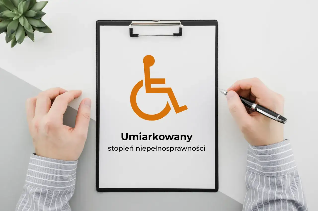 Na tablicy widnieje symbol osoby na wózku inwalidzkim i napis "Umiarkowany stopień niepełnosprawności".