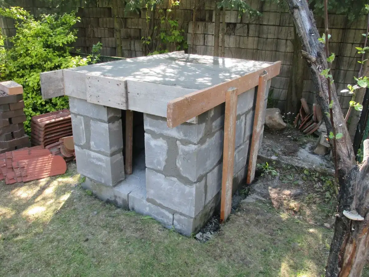 Budowa pieca chlebowego w ogrodzie. Konstrukcja z bloczków betonowych z drewnianym szalunkiem pod strop.