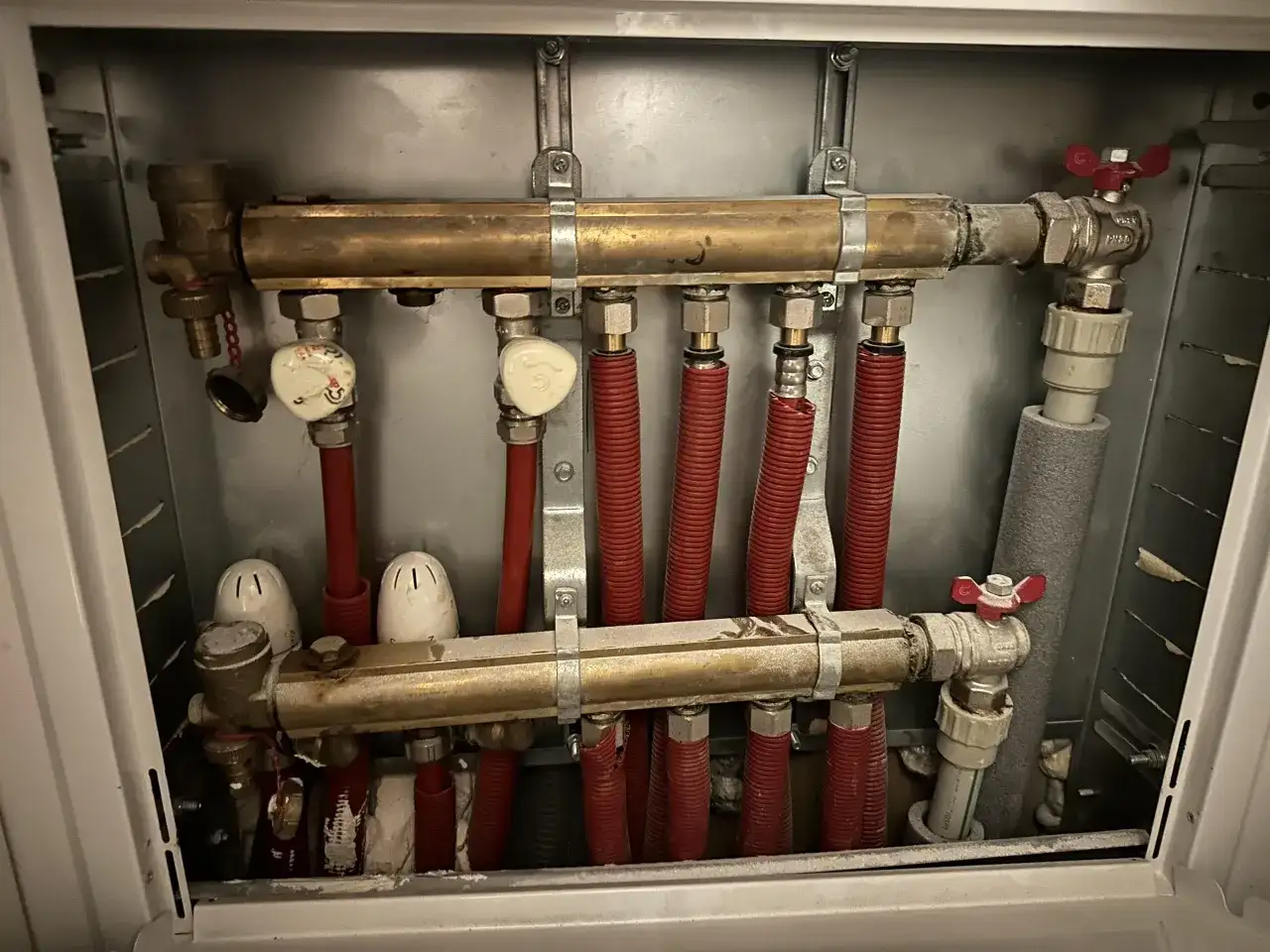 Rozdzielacz ogrzewania podłogowego z zaworami. Dowiedz się, jak zakręcić ogrzewanie podłogowe, zamykając dopływ wody.