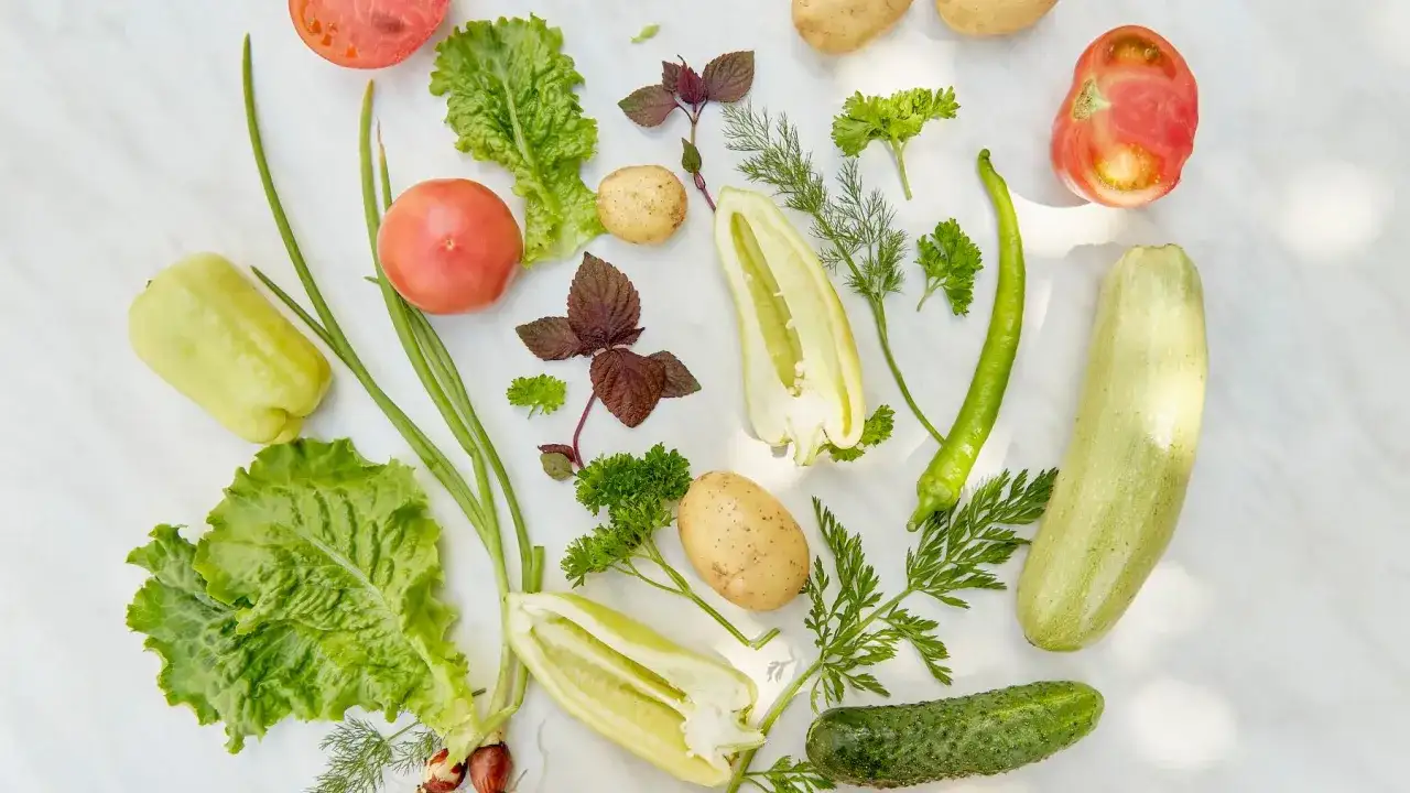 Kolorowe warzywa: pomidory, sałata, papryka, ziemniaki, cukinia, ogórek, szczypiorek, zioła. To idealne składniki tego, co jedzą wegetarianie.